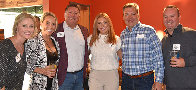 A group of advisors, Cornerstone staff, and wholesale partners stand together smiling