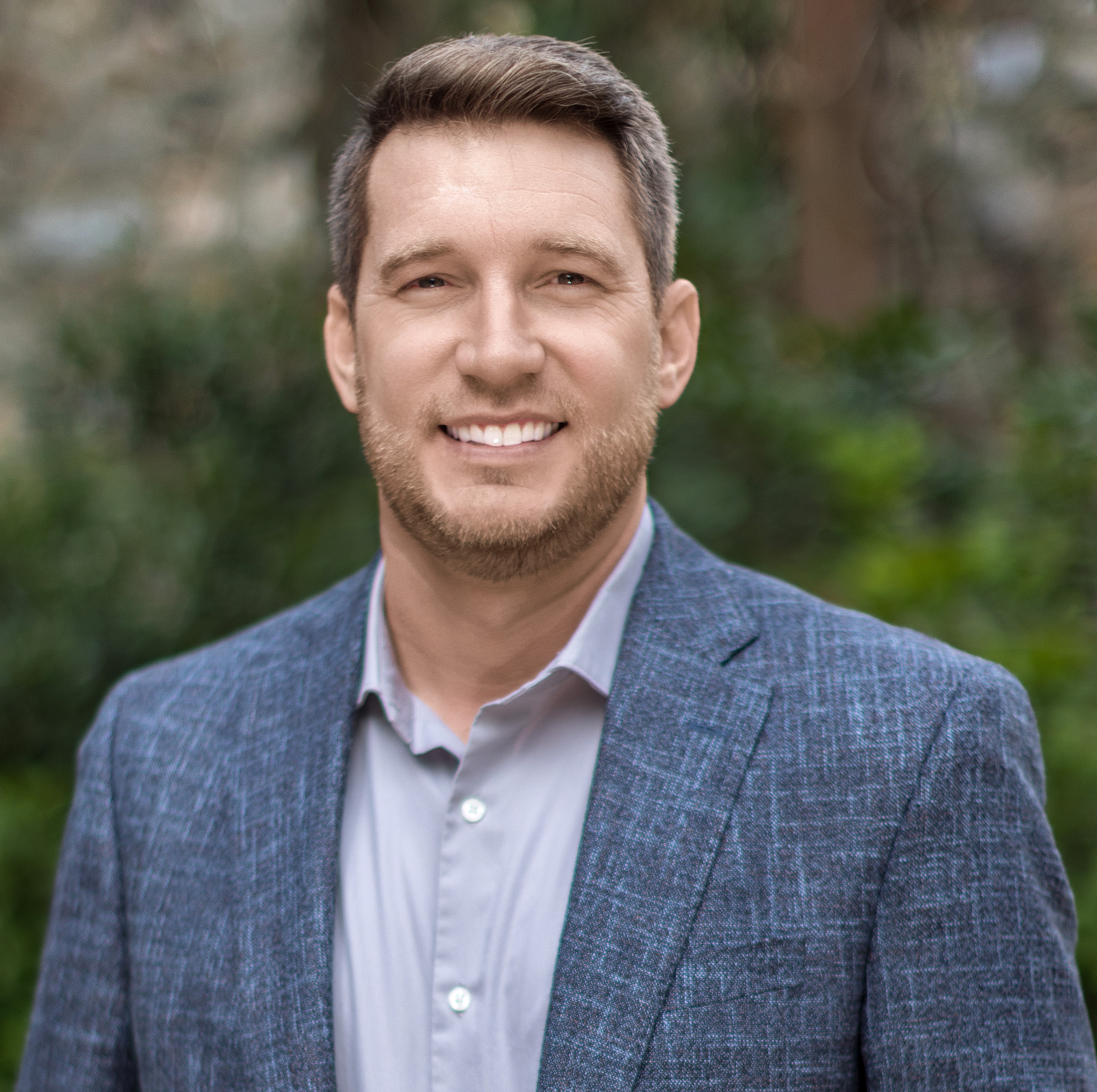 Headshot of advisor Alan Spraggins, wearing a blue blazer and light shirt